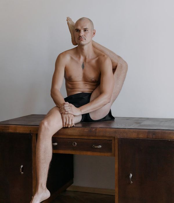 Man performing a controlled strength exercise in a minimalist bright studio.